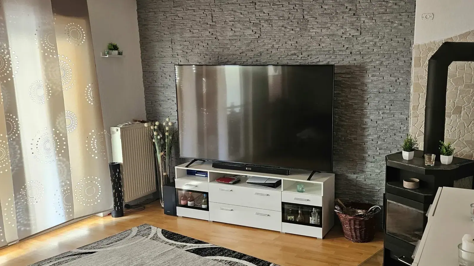 Wohnzimmer eines Bremer Wohnhauses mit Kaminofen, Holzboden und gemütlicher Einrichtung.