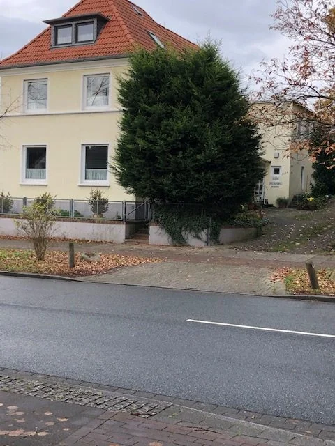 Gepflegtes Wohnhaus mit gelbem Giebel an einer ruhigen Bremer Straße.